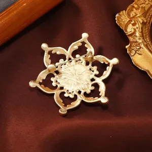 Detailed back view of a vintage hollow lotus brooch in matte gold finish with safety pin