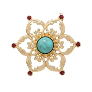 Vintage gold-tone openwork lotus brooch with large turquoise center and red stone accents