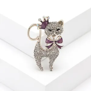 Primo piano di una spilla a forma di gatto con strass scintillanti, corona e fiocco viola