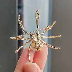 Detailed back view of a vintage golden spider brooch featuring a pearl and pin closure