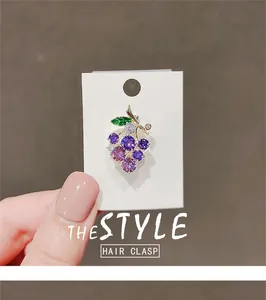 Detailed view of elegant purple grape brooch featuring sparkling crystals and a green leaf