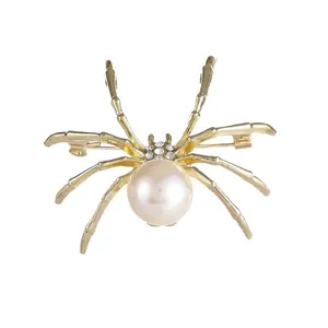 Elegant vintage golden spider brooch featuring a large pearl and sparkling rhinestone accents