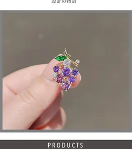 Detailed view of the purple grape brooch with sparkling rhinestones and green leaf