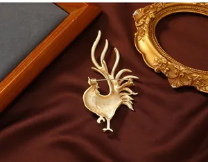 Detailed back view of gold-toned rooster brooch showing secure pin closure mechanism