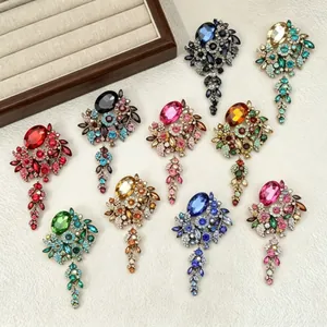 Macro detail of various colorful retro rhinestone tassel brooches on textured background