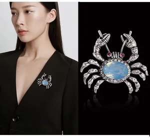 Detailed view of an elegant silver crab brooch with blue stone and sparkling rhinestones