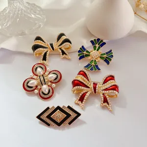 Vue détaillée de cinq broches vintage de luxe en émail avec perles et pierres