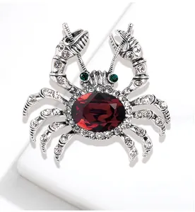 Detailed macro view of a vintage silver crab brooch with a large red faceted central gem