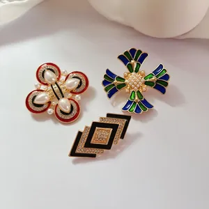Gros plan de trois broches élégantes en émail et perles de style palais vintage