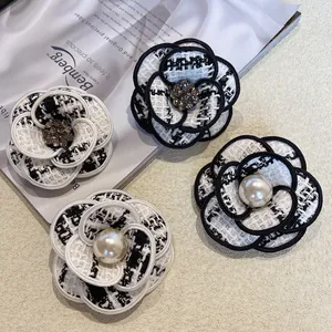 Vue détaillée d'élégantes broches camélia en tweed avec perles et strass scintillants