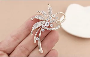 Detailansicht einer funkelnden Strass-Blumenbrosche mit Roségold-Finish Accessoire