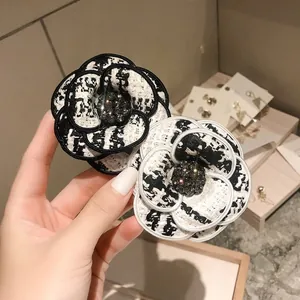 Broche fleur camélia classique en tweed noir et blanc avec décor de cristal élégant