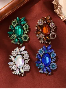 Macro view of vintage rhinestone brooches in four colors with intricate floral crystal patterns