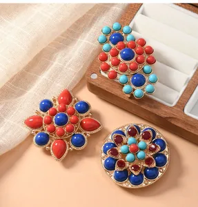 Detailed view of ethnic style lotus brooches with vibrant colorful beads in jewelry box