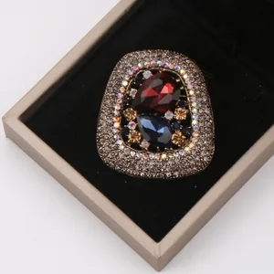 Detailed view of luxurious vintage brooch with red and blue crystals in gift box