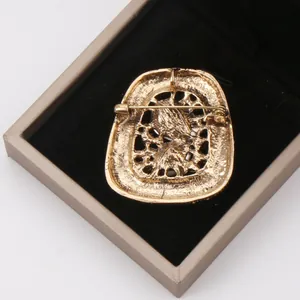 Detailed back view of vintage gold-toned brooch with secure safety pin closure