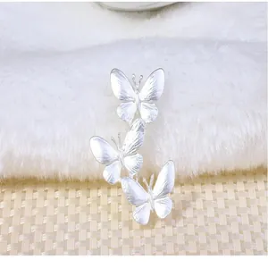 Macro detail of three elegant silver alloy butterflies minimalist brooch pin accessory