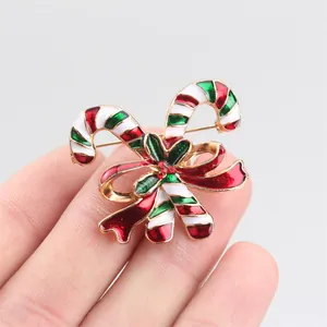 Detailansicht einer festlichen Weihnachts-Zuckerstangen-Brosche mit roter Strass-Schleife.