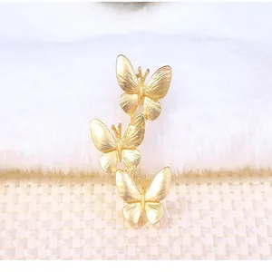 Detailed close-up of a stylish gold-plated brooch featuring three elegant butterflies