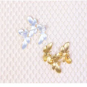 Detailed back view of elegant triple butterfly alloy brooch pins in gold and silver finishes