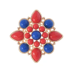 Vintage ethnic style flower brooch with red and blue imitation stones in gold finish