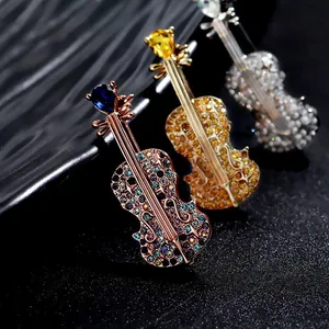 Detailed view of elegant violin brooches with colorful crystals and metallic finishes