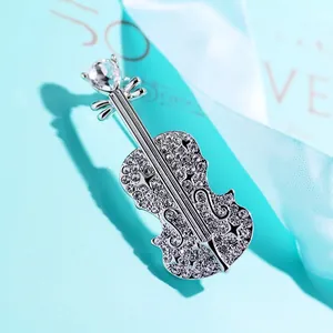 Exquisite silver crystal violin brooch with rhinestone detailing on a blue background