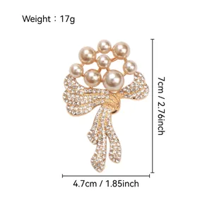 Detail view showing size dimensions of a pearl and crystal bow brooch, 17g weight