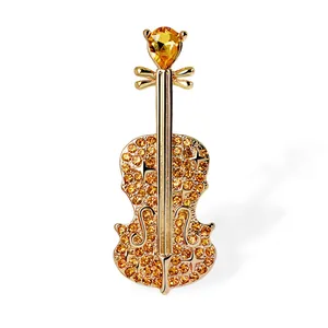 Elegant gold-toned violin brooch adorned with sparkling orange crystals and rhinestones