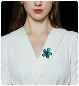 Detailaufnahme einer eleganten grünen Kristallblumenbrosche an einem weißen Revers