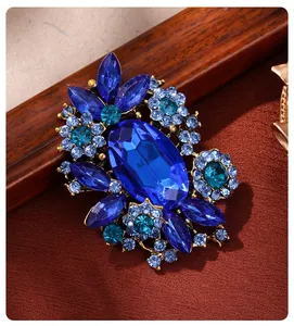 Macro detail of a vintage royal blue glass gemstone brooch with rhinestone accents