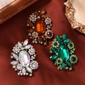 Vintage crystal rhinestone floral brooches in emerald green, amber, and iridescent white