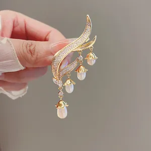 Detailed view of elegant lily of the valley tassel brooch with pearls and stones