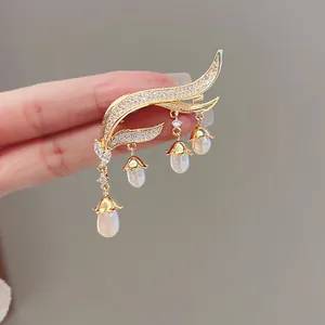 Detailed view of lily of the valley brooch with crystal tassels and white pearls