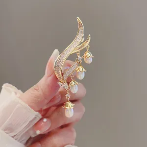 Elegant close-up of lily of the valley brooch with golden tassels and dangling pearls