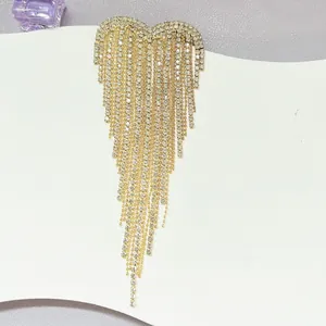 Detailansicht einer eleganten Gold-Herz-Brosche mit langen funkelnden Strassquasten