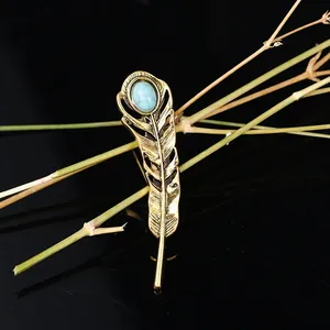 Detailed macro shot of vintage antique gold feather brooch with oval turquoise stone