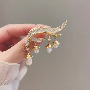 Close-up of an elegant Lily of the Valley tassel brooch with pearls and crystals