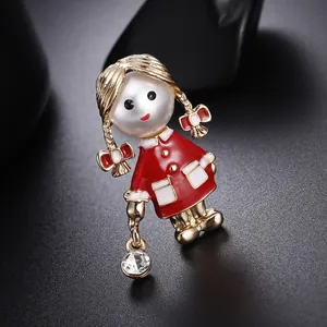 Gros plan d'une broche petite fille avec visage en perle et robe émaillée.