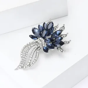 Primo piano dettagliato di una spilla a fiore con cristalli blu scuro e strass