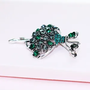 Detailed macro view of an elegant ballerina brooch with sparkling green rhinestone accents.