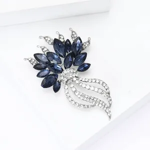 Dettaglio dell'elegante spilla a fiore con strass blu e bianchi per abiti da donna