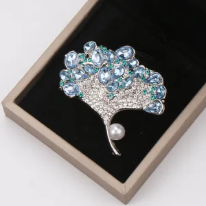 Elegant ginkgo leaf brooch with blue crystals and white pearl in a premium jewelry box