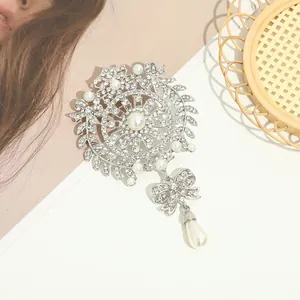 Nahaufnahme der luxuriösen silbernen Brosche mit Strass, Schleife und Perle