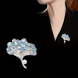 Elegant silver-tone ginkgo leaf brooch featuring sparkling blue crystals and a white pearl