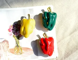 Macro detail of red, yellow, and green bell pepper brooches with rhinestone accents.