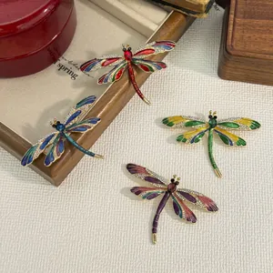 A collection of four exquisite enamel dragonfly brooches with rhinestone wings