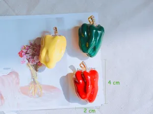 Detail showing rhinestone-studded bell pepper brooches in red, green, and yellow.