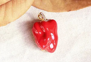Close-up of glossy red bell pepper brooch with sparkling rhinestone stem detail.