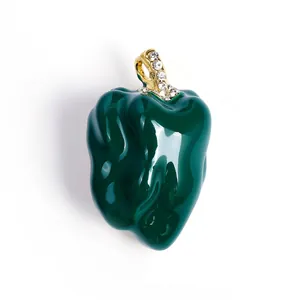 Detail shot of a dark green enamel pepper brooch with sparkling rhinestone accents